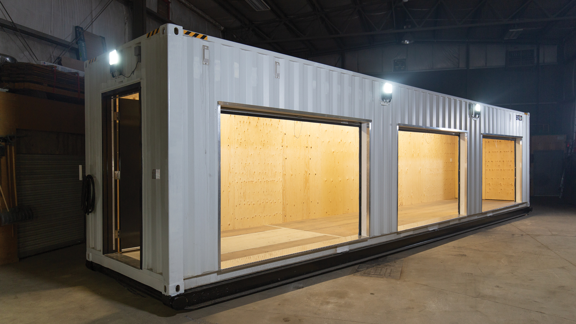 Exterior photo of large container with three bay doors opened showing the inside of the container